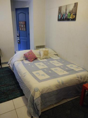 een bed in een slaapkamer met een blauwe deur bij Rez-de-chaussée Majorque centre de Perpignan in Perpignan