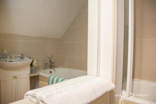 a bathroom with a bath tub and a sink at Lovely 1bed Suite close to Beach and with Parking - Sky View Suite in Bournemouth