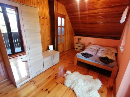 a bedroom with a bed and a large window at Heniowy Domek in Ogonki