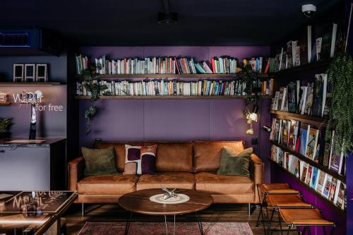 a living room with a couch and bookshelves at Capsule Hotel - Lucerne Old Town in Luzern