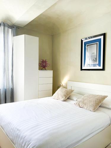 a bedroom with a large bed with white sheets at ComeCasa San Secondo White in Asti