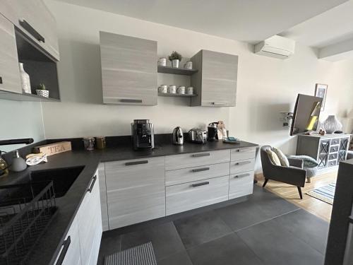 a kitchen with white cabinets and a black counter top at L'équinoxe in Collioure