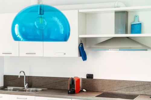 une cuisine avec un évier et une plaque bleue dans l'établissement My home at the Como Lake - private parking, à Côme