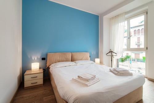 - une chambre avec un grand lit et un mur bleu dans l'établissement My home at the Como Lake - private parking, à Côme