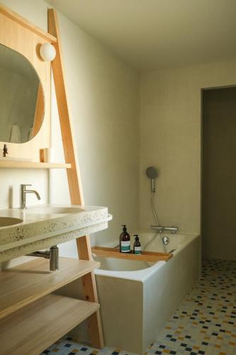 a bathroom with a sink and a bath tub at Hotel des Dunes in Cap-Ferret