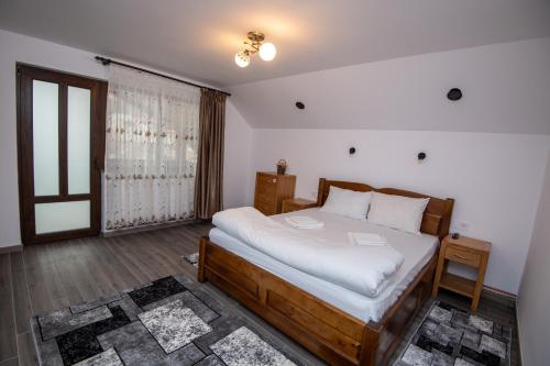 a bedroom with a bed and a window at Pensiunea Teona in Târgu Ocna