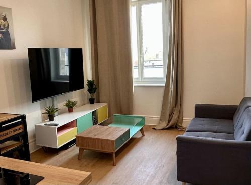 a living room with a couch and a tv at Britich 3D: Suite spa privé, clim, thermal/Artem in Nancy