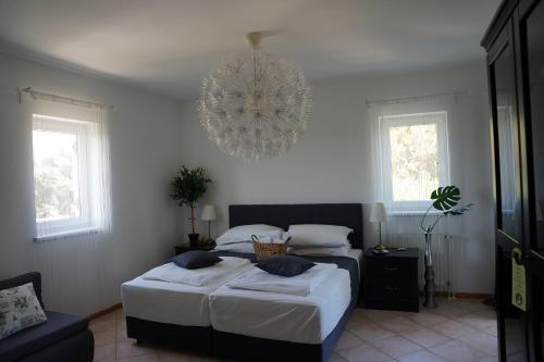 a bedroom with two beds and a chandelier at Villa Olea in Šimuni