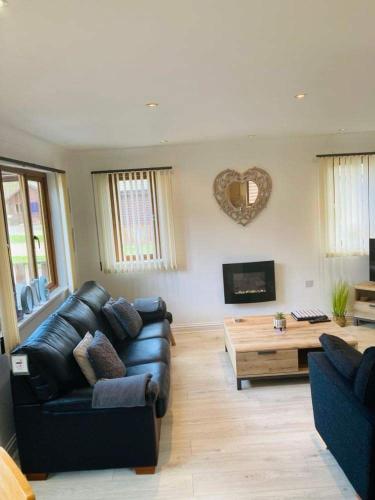 a living room with a couch and a coffee table at FourPar Lodge-Stunning lodge in a great location in Sewerby