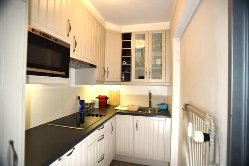 a kitchen with white cabinets and a black counter top at Leuven Centrum Comfort in Leuven