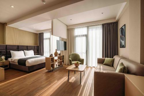 a hotel room with a bed and a couch at Hotel Monday by DNT Group in Tbilisi City