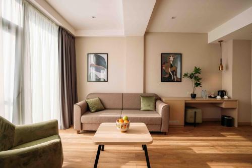 a living room with a couch and a table at Hotel Monday by DNT Group in Tbilisi City