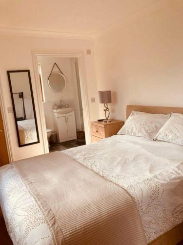 a bedroom with a white bed and a mirror at FourPar Lodge-Stunning lodge in a great location in Sewerby