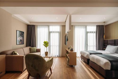 a hotel room with a bed and a couch at Hotel Monday by DNT Group in Tbilisi City