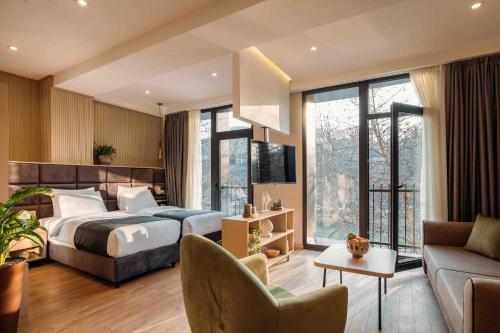 a hotel room with a bed and a couch at Hotel Monday by DNT Group in Tbilisi City