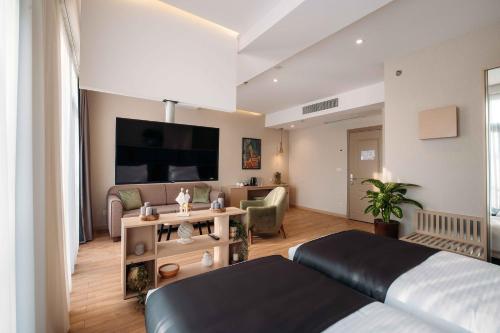 Hotel Monday by DNT Group في تبليسي: غرفة نوم مع سرير وغرفة معيشة