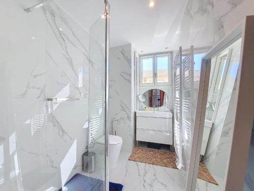 La salle de bains blanche est pourvue de toilettes et d'un miroir. dans l'établissement Nestor&Jeeves - LA MAREE BLEUE - TERRACE - NEAR BEACH, à Nice