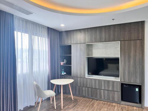 een woonkamer met een tafel en een televisie bij Le Anh Hotel in Phu Quoc