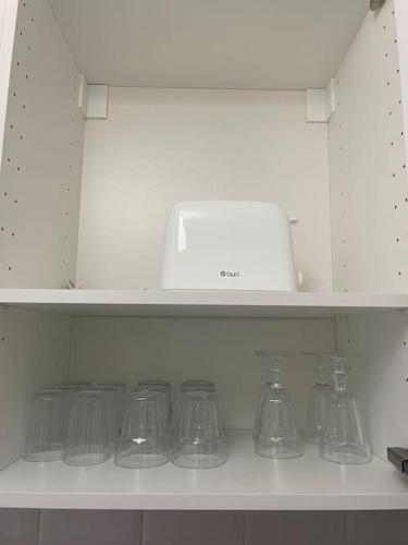 une rangée d'objets en verre sur une étagère dans une cuisine dans l'établissement Logement de charme à cachan, à Cachan