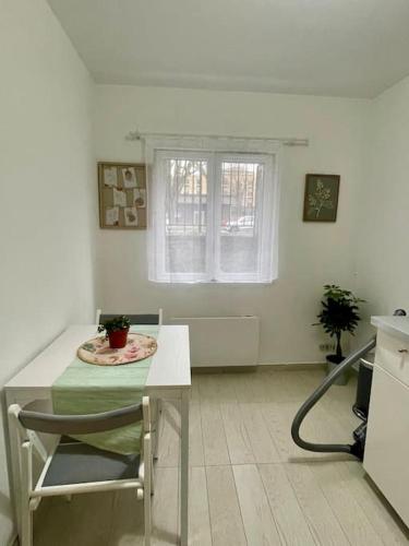 a white kitchen with a table and a window at Logement de charme à cachan in Cachan