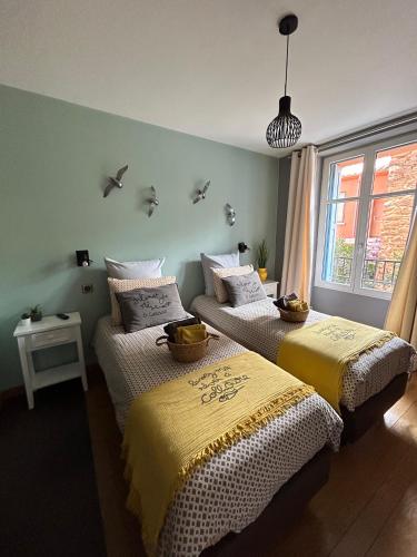 - 2 lits dans une chambre avec des oiseaux sur le mur dans l'établissement L'équinoxe, à Collioure