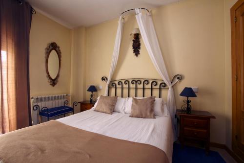 a bedroom with a bed with a canopy at Hotel Arco San Vicente in Avila