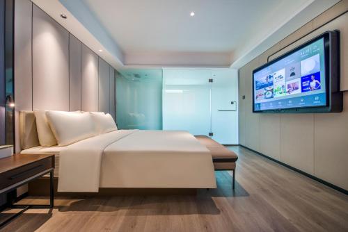 a bedroom with a bed and a flat screen tv at Atour X Hotel Dongguan Chang'an Wanda in Dongguan
