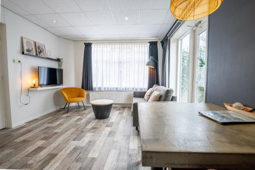 a living room with a couch and a table at De Berkenhof in Nes