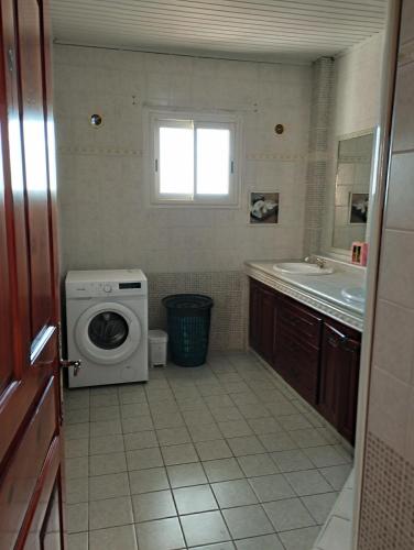a bathroom with a washing machine and a sink at Appartement 974 in Le Tampon