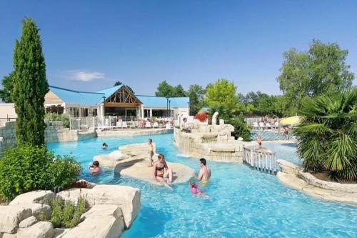een groep mensen in een zwembad in een resort bij Mobilhome 5 étoiles - Piscine - ef0ghd in Sainte-Catherine-de-Fierbois