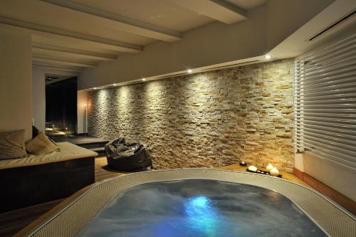 a jacuzzi tub in a room with a stone wall at Piccolo Hotel Aurora in Abbadia San Salvatore