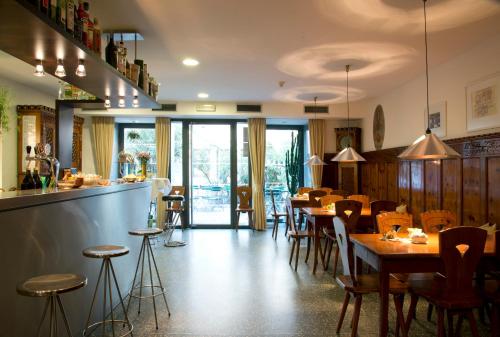 a restaurant with tables and chairs and a bar at Hotel Figl ***S in Bolzano