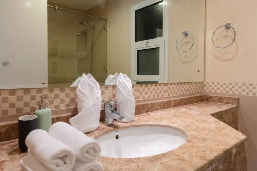 a bathroom with a sink with towels on it at Stella Stays Stunning 1 BDR Dubai Tecom Netflix Pool in Dubai