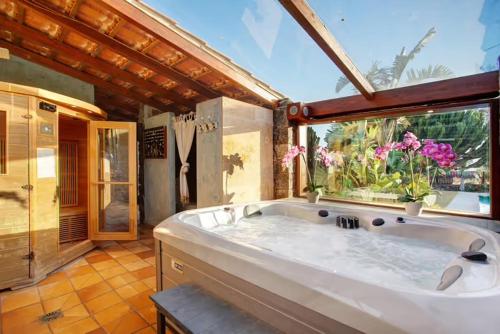 a large bathroom with a large tub with a window at Villa Masé Fuerteventura in La Asomada