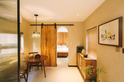 una camera con una camera da letto, un tavolo e un letto di 禾煦的家-和煦 HX house a Qingdao