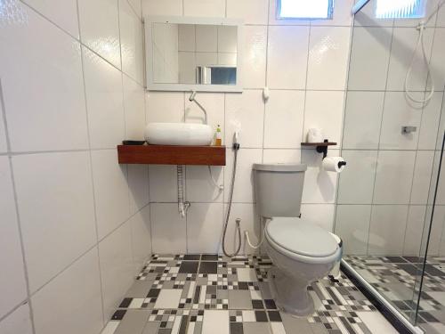 a bathroom with a toilet and a sink at Dunas Apart Refugio Completo a 1Km Praia de St Antonio in Diogo