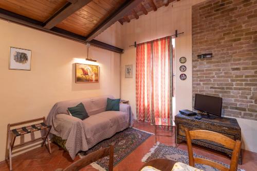 a living room with a couch and a tv at Appartamento Le Rondini in San Gimignano