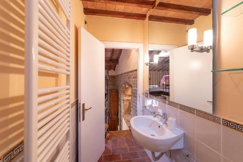 サン・ジミニャーノにあるAppartamento Le Rondiniのバスルーム(洗面台、鏡付)