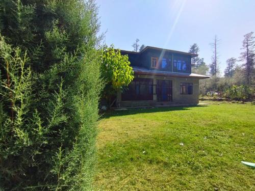 ein Haus in einem Hof mit einem Rasenplatz sidx in der Unterkunft Sheraz Guest House , Tangmarg in Tangmarg