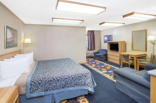 una camera d'albergo con letto e scrivania di Days Inn by Wyndham Farmer City a Farmer City