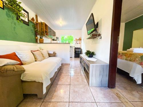 a living room with a couch and a television at Dunas Apart Refugio Completo a 1Km Praia de St Antonio in Diogo