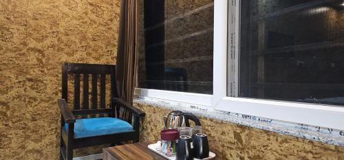 馬蘇里的住宿－Hotel Mussoorie Gold Mary，靠窗边的桌子和椅子