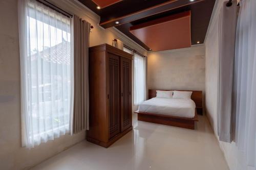 a bedroom with a bed and a large window at Tebluess Gianyar in Bedahulu
