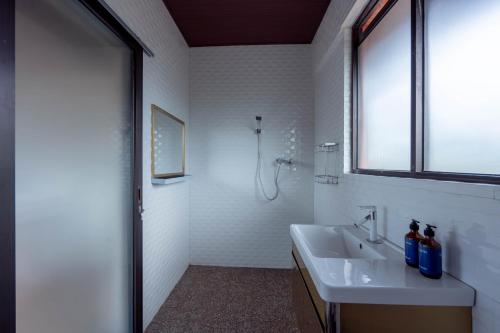 La salle de bains blanche est pourvue d'un lavabo et d'une fenêtre. dans l'établissement The Lavana Tebluess Gianyar, à Bedahulu