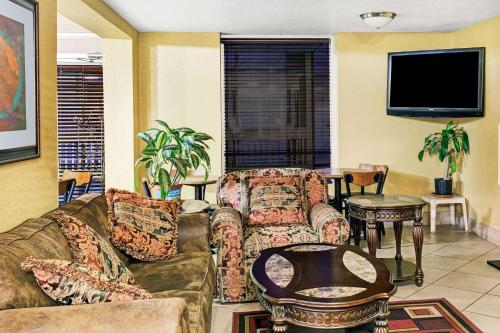 a living room with a couch and a tv at Days Inn & Suites by Wyndham Downtown Gatlinburg Parkway in Gatlinburg