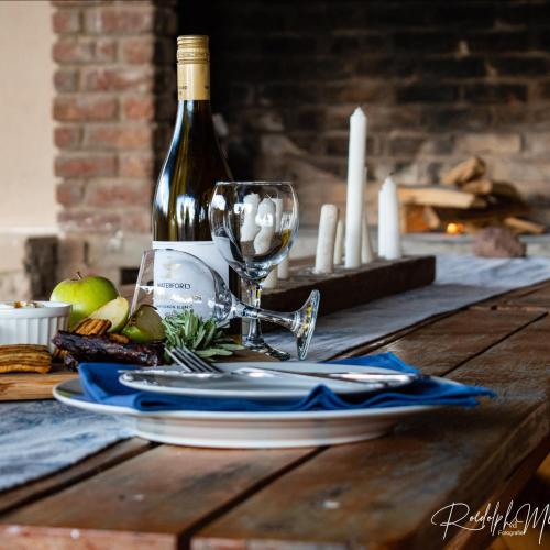 a table with a bottle of wine and a glass at Raapfontein Self-catering in Hanover