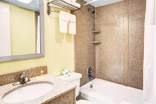 y baño con lavabo, aseo y ducha. en Days Inn & Suites by Wyndham Downtown Gatlinburg Parkway, en Gatlinburg
