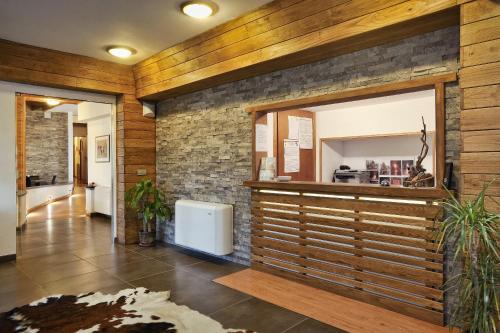 a lobby with a counter and a brick wall at Piccolo Hotel Aurora in Abbadia San Salvatore