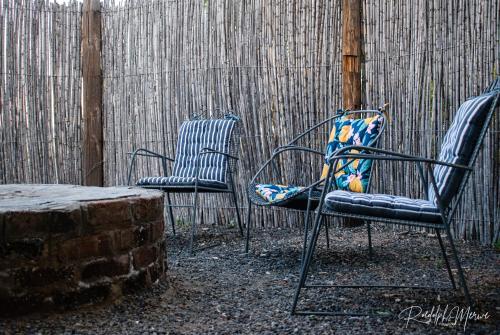 two chairs and a table in front of a fence at Raapfontein Self-catering in Hanover