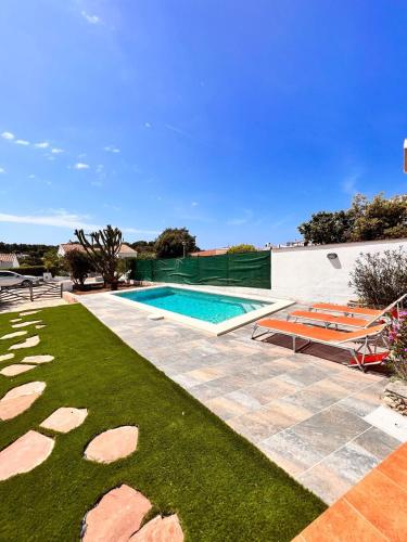 a backyard with a swimming pool and a lawn at Casa a pocos minutos de la playa de Cala Galdana in Cala Galdana